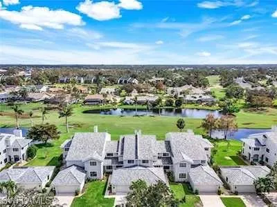 Aerial view of residential area with a large body of water and a golf club