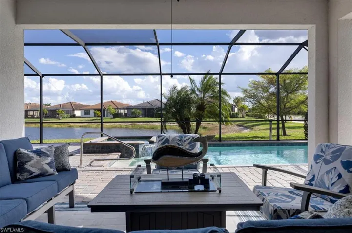View of patio featuring a sunroom, an outdoor pool, a residential view, and an outdoor hangout area
