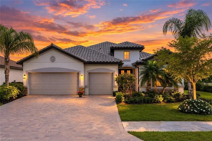 Mediterranean / spanish-style house with a garage, decorative driveway, stucco siding, a lawn, and a tile roof