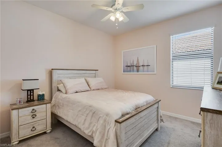 Carpeted bedroom with baseboards and ceiling fan