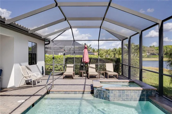 Integrated pool / hot tub featuring a lanai, a sunroom, a patio, and a water view
