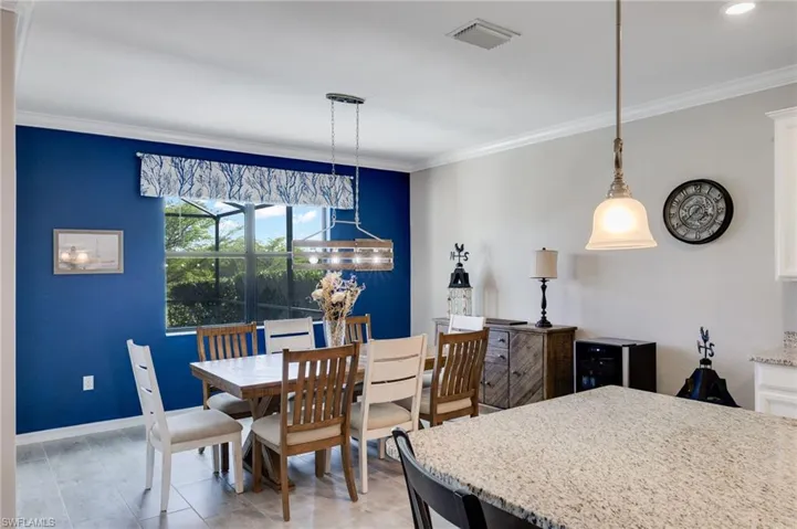 Dining area with ornamental molding and wine cooler