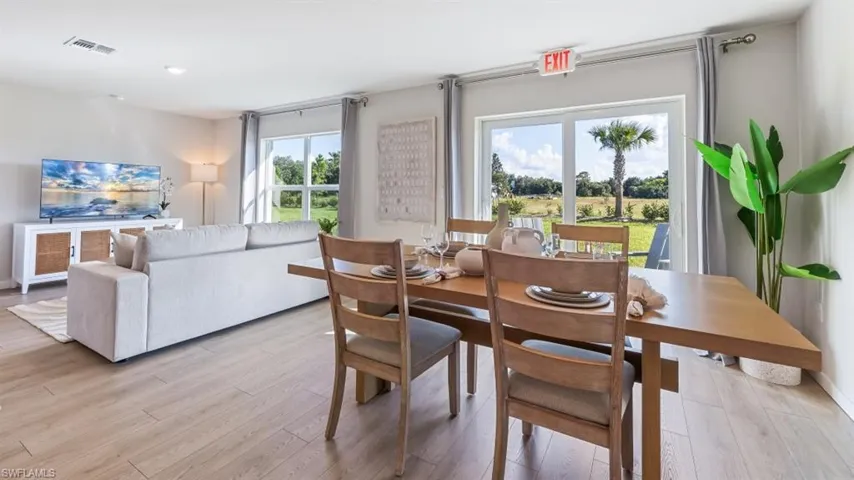 Model home. Dining area with light wood-type flooring