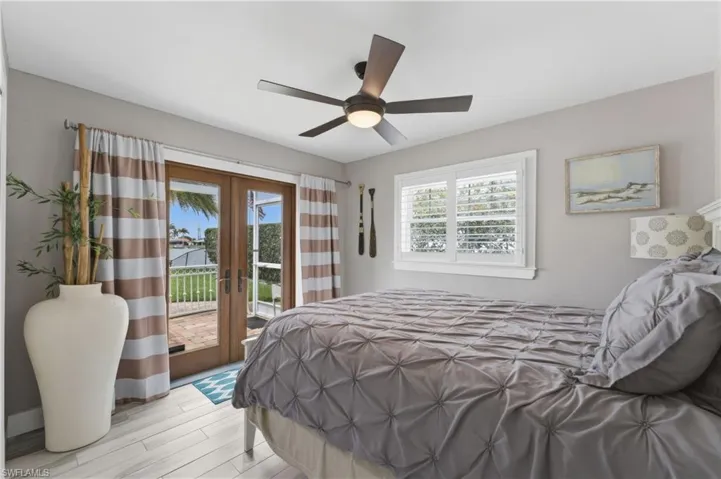Bedroom featuring light wood-finish flooring, a ceiling fan with integrated lighting, and neutral wall tones
