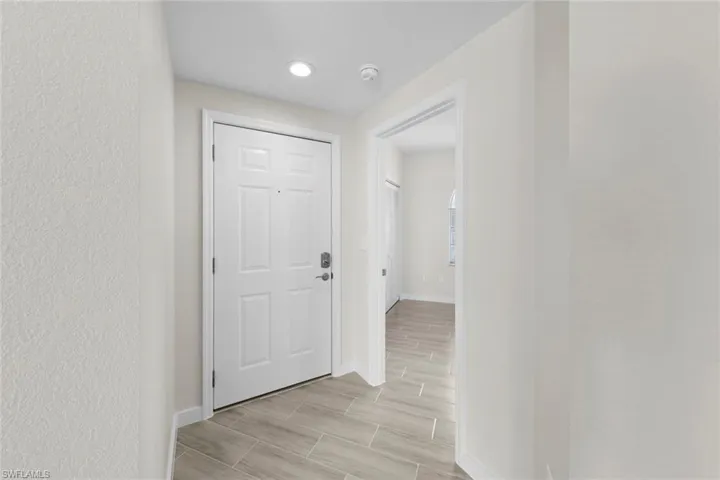 Corridor featuring baseboards and wood finish floors