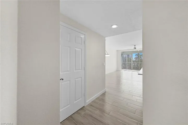Hall featuring wood tiled floors, recessed lighting, a textured wall, and a textured ceiling