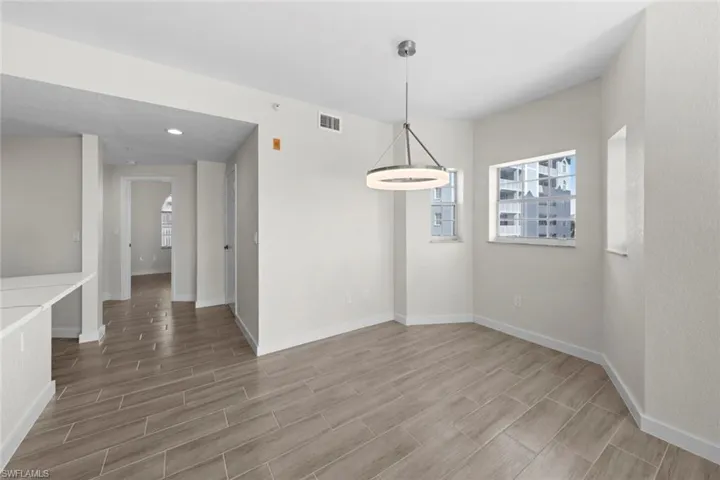 Unfurnished dining area featuring wood finish floors and recessed lighting