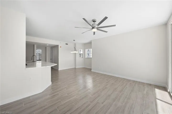 Unfurnished living room featuring ceiling fan and wood tiled floors