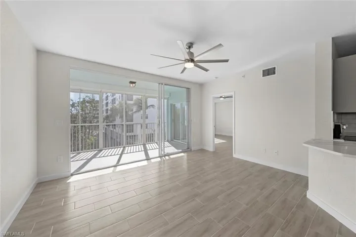 Unfurnished living room with ceiling fan and wood tiled floors