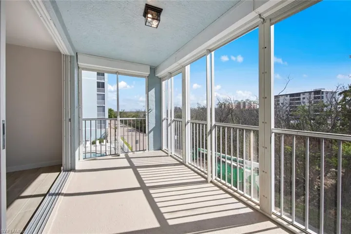 Unfurnished sunroom with a textured ceiling and wood finished floors
