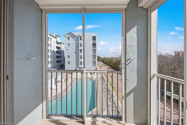 Balcony with view of pool and a sunroom