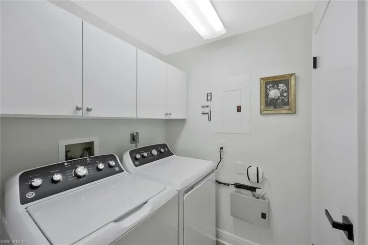 Laundry area with electric panel, washing machine and dryer, and cabinet space