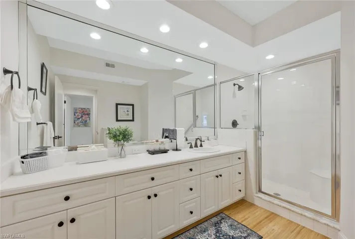 Bathroom with a stall shower, vanity, light wood-type flooring, and recessed lighting