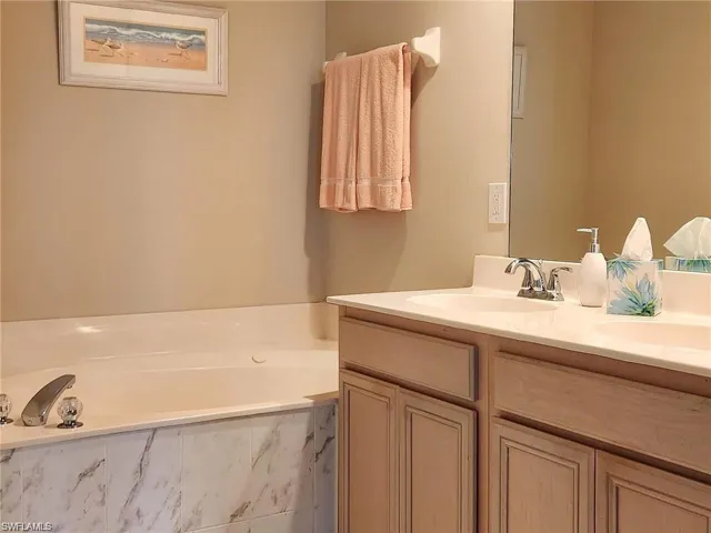 Bathroom with tiled tub and vanity