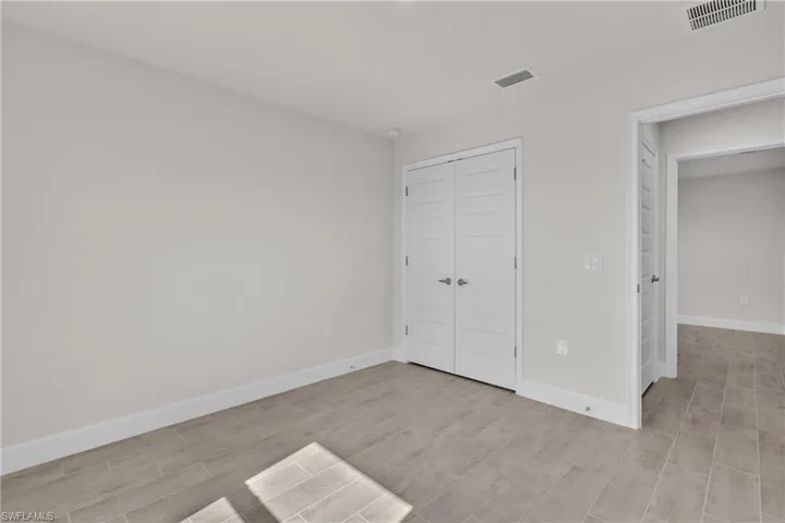 Unfurnished bedroom with wood tiled floors and a closet