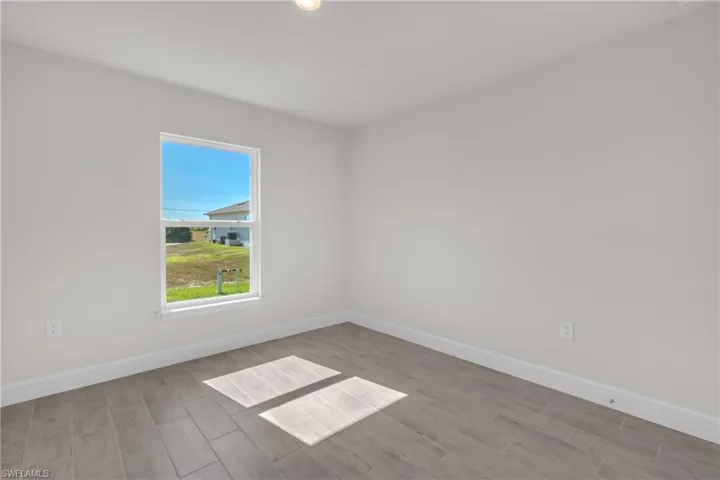 Spare room with baseboards and wood tiled floors