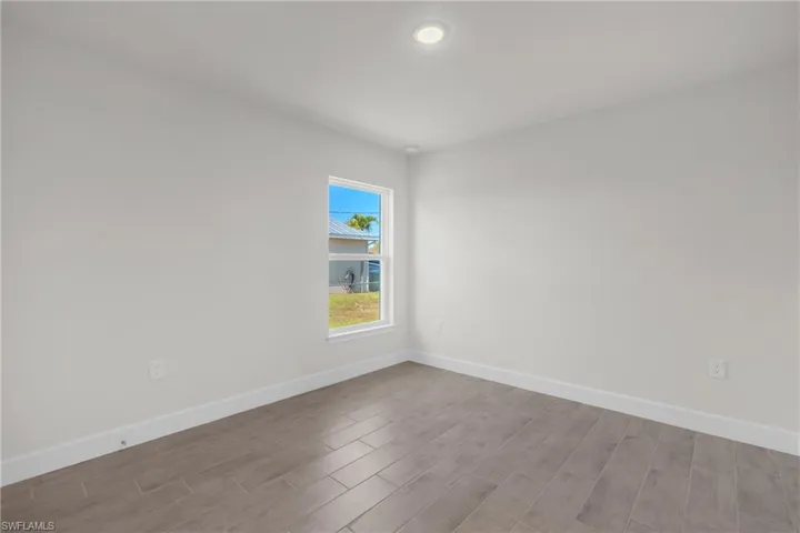 Spare room featuring wood tiled floors and recessed lighting