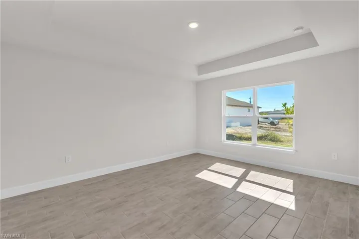 Unfurnished room with wood tiled floors, a tray ceiling, and recessed lighting