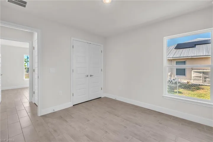 Unfurnished bedroom featuring wood tiled floors and a closet