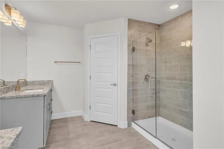 Bathroom featuring vanity and a shower stall