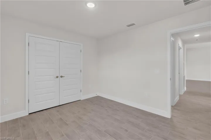 Unfurnished bedroom featuring a closet, recessed lighting, and wood finish floors
