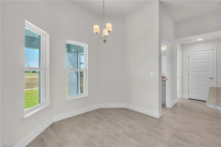 Unfurnished dining area featuring a chandelier and wood finish floors