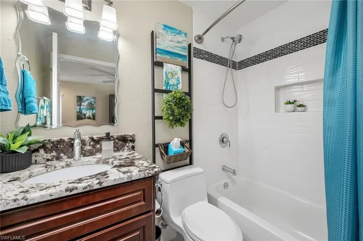 Full bathroom featuring shower / tub combo with curtain, vanity, and toilet