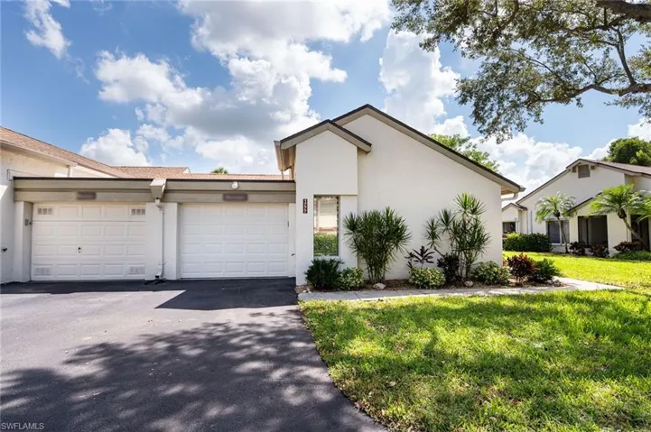 View of front of house with a garage and a front lawn