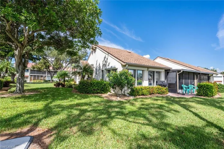 Rear view of property featuring a yard and a sunroom