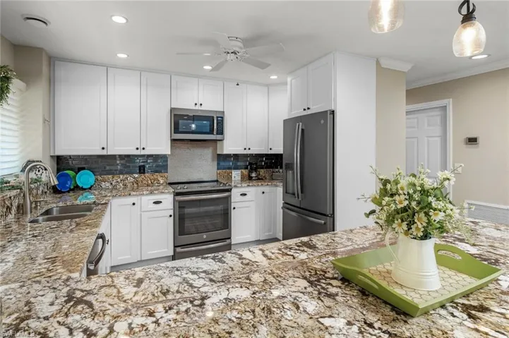 Kitchen featuring appliances with stainless steel finishes, sink, and white cabinets