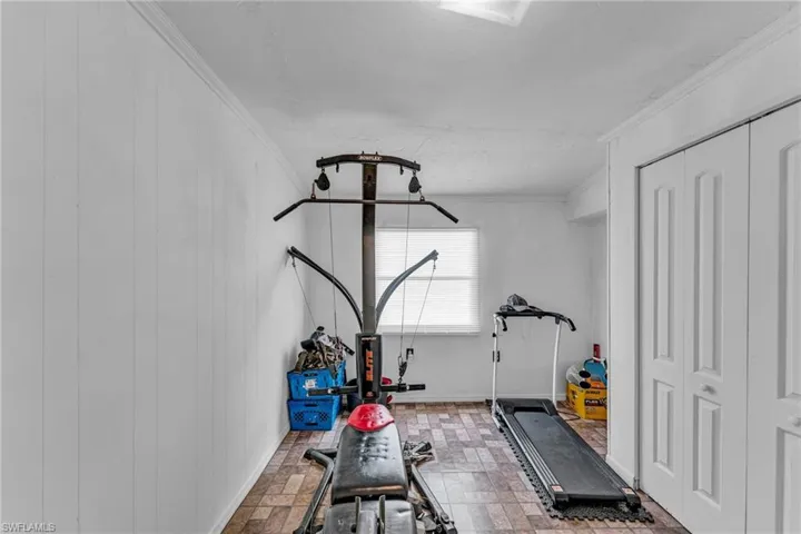 Workout area featuring ornamental molding