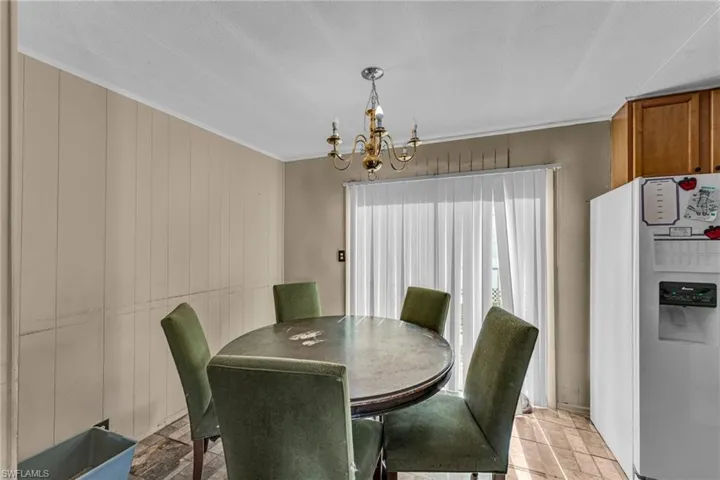 Dining area featuring an inviting chandelier and wood walls