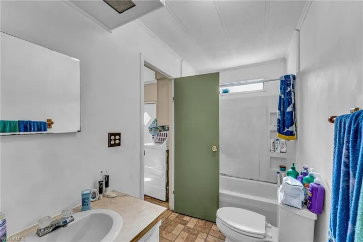 Full bathroom featuring vanity, washer / clothes dryer, bathing tub / shower combination, and toilet