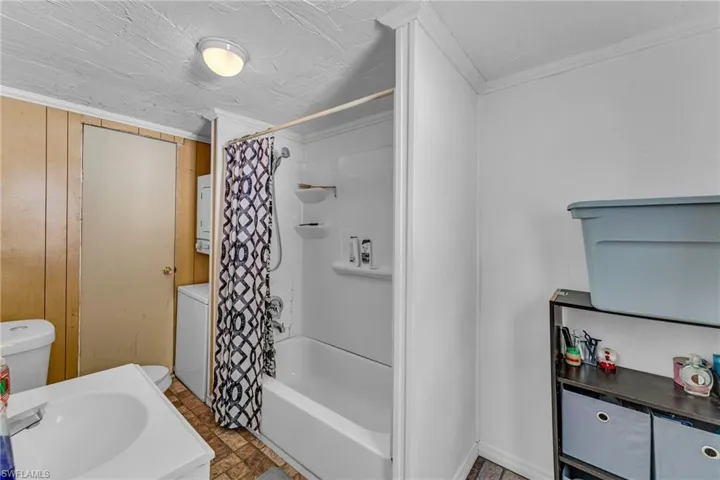 Bathroom featuring ornamental molding, sink, and shower / bath combo