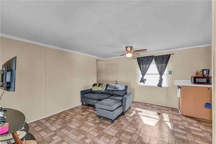 Sitting room with ornamental molding and ceiling fan