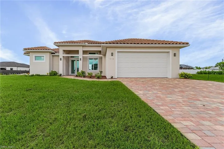 Mediterranean / spanish house featuring a garage and a front lawn