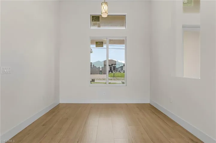 Spare room featuring a healthy amount of sunlight and light hardwood / wood-style flooring