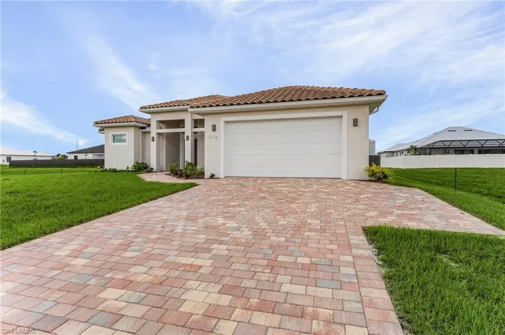 Mediterranean / spanish house with a garage and a front lawn