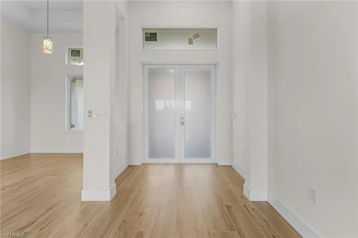 Entrance foyer with french doors and light wood-type flooring