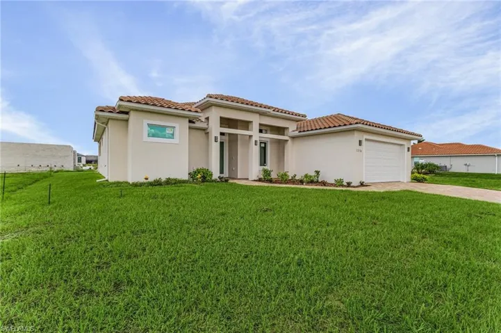 Mediterranean / spanish house with a garage and a front yard