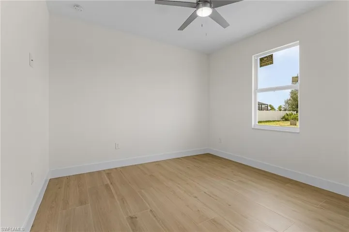 Empty room featuring ceiling fan and light wood-type flooring