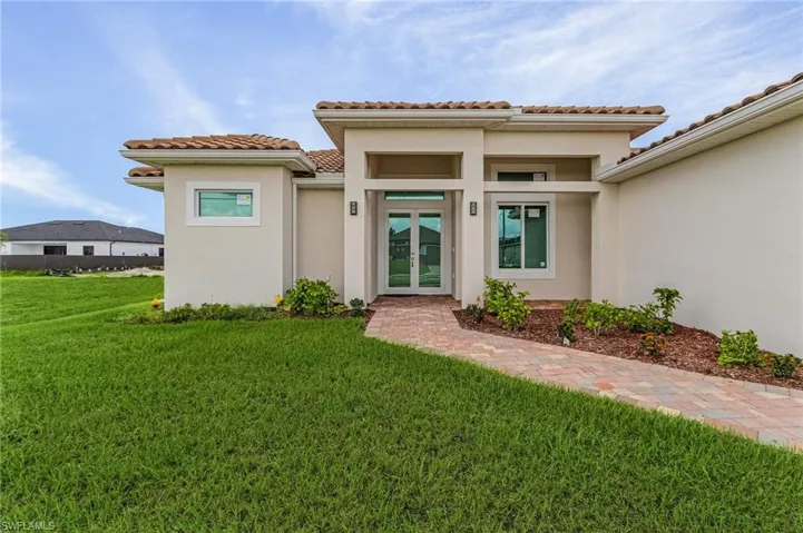 View of exterior entry with a yard