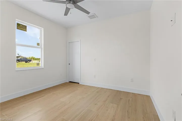 Empty room with ceiling fan and light hardwood / wood-style floors