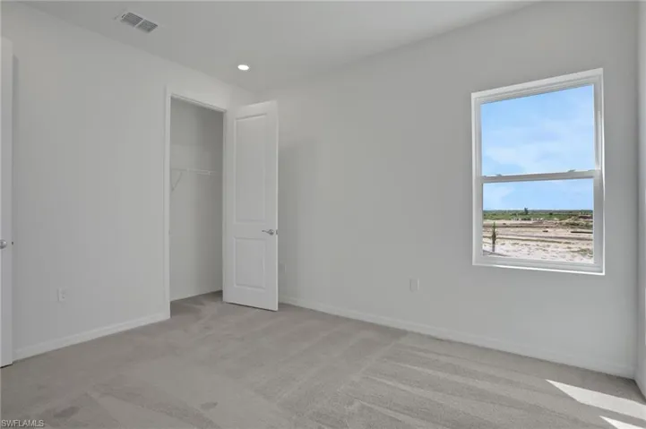 Unfurnished bedroom with light colored carpet, recessed lighting, and a closet