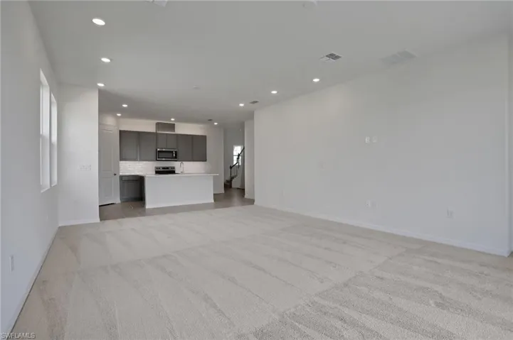 Unfurnished living room with recessed lighting and light colored carpet