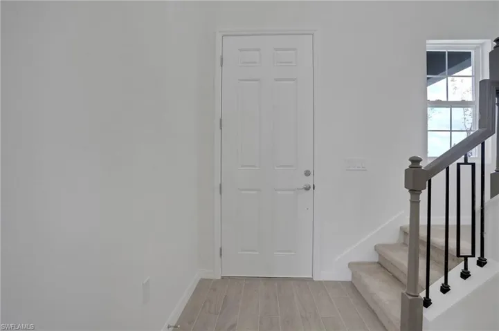 Foyer entrance featuring stairs and wood tiled floors