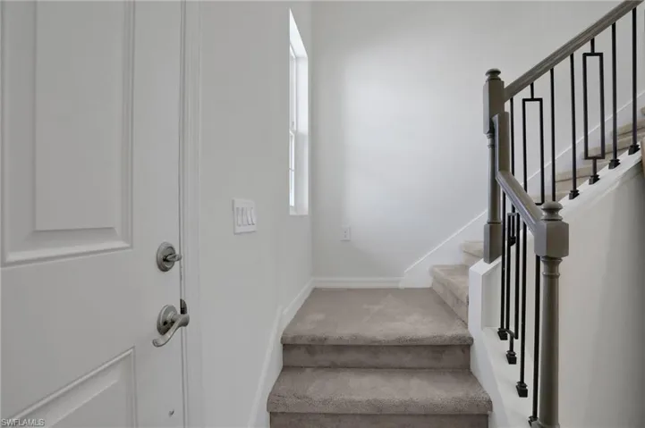 Staircase with baseboards and carpet