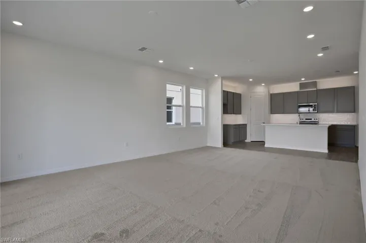 Unfurnished living room with recessed lighting and light colored carpet