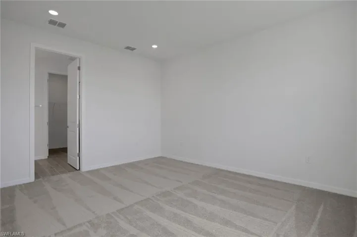 Empty room featuring light colored carpet and recessed lighting