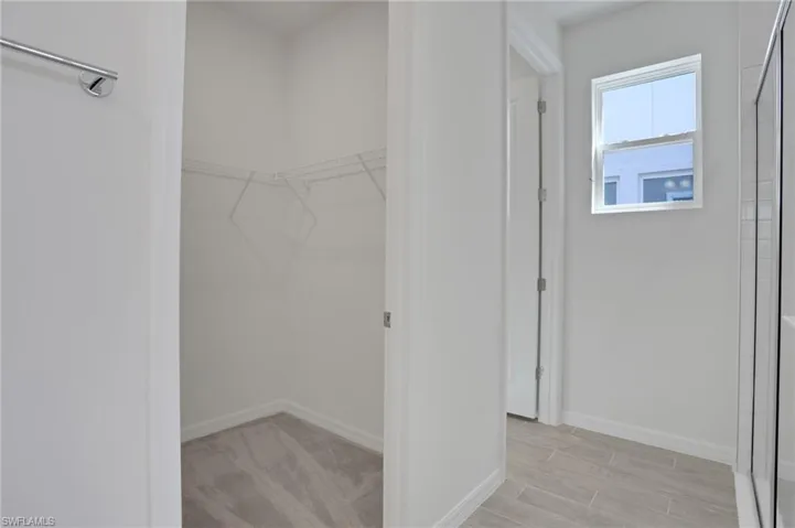 Walk in closet with wood finish floors